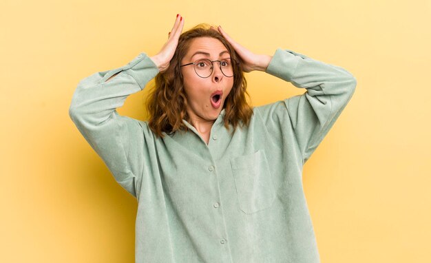 Avec la bouche ouverte à l'air horrifié et choqué à cause d'une terrible erreur levant les mains à la tête