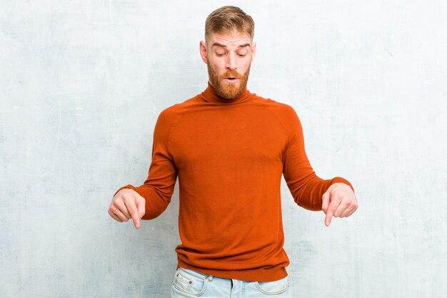 avec la bouche ouverte pointée vers le bas avec les deux mains, l'air choqué, étonné et surpris