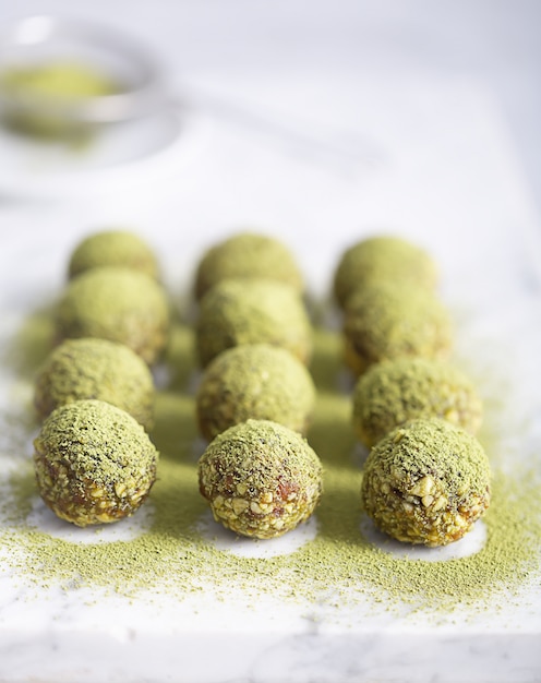 Bouchées ou boules d'énergie matcha sans cuisson, préparées avec des ingrédients naturels, tels que noix, poudre de matcha, dattes