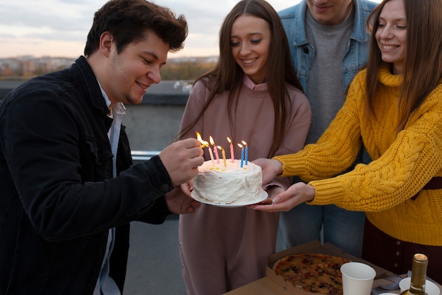 Bouchent des amis heureux avec un gâteau