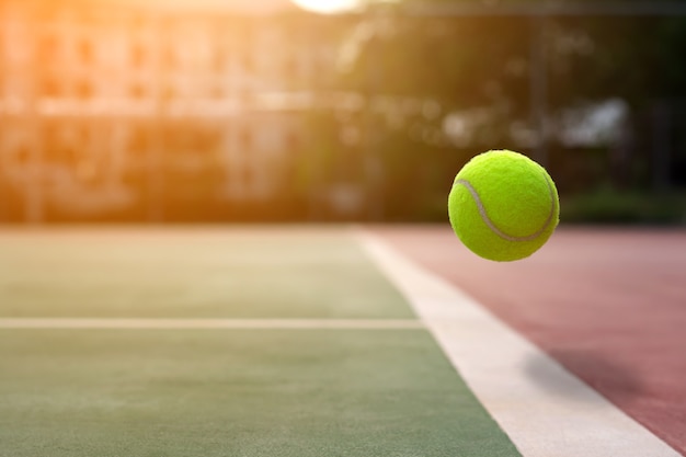 Bouchent la balle de tennis sur le fond des cours