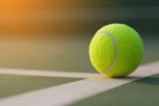 Bouchent la balle de tennis sur le fond des cours