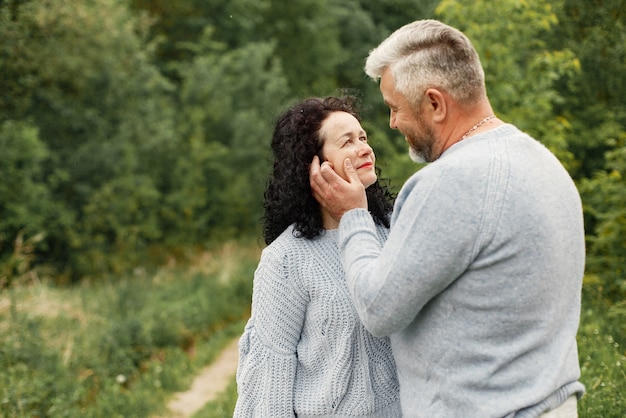 Bouchent couple romantique debout dans le parc d'automne dans la journée