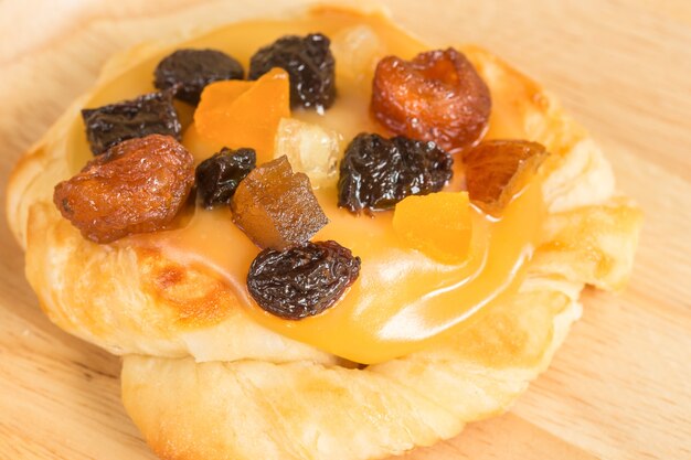 Bouchent la crème anglaise avec des fruits secs mélangés sur un plat en bois