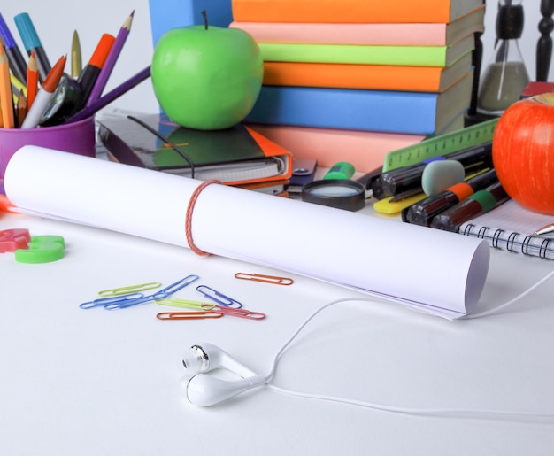 Bouchent une feuille de papier à dessin et de fournitures scolaires isolé sur fond blanc