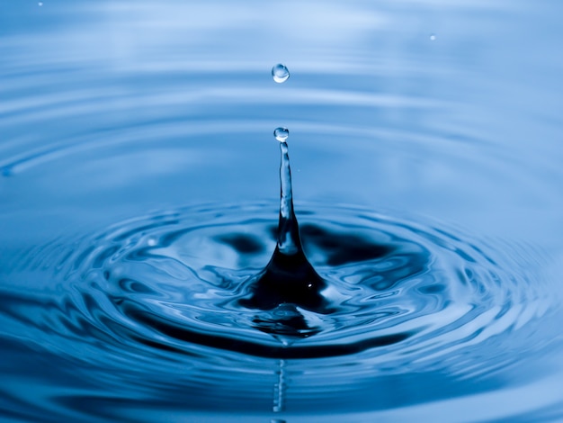 Bouchent la goutte d&#39;eau sur fond bleu