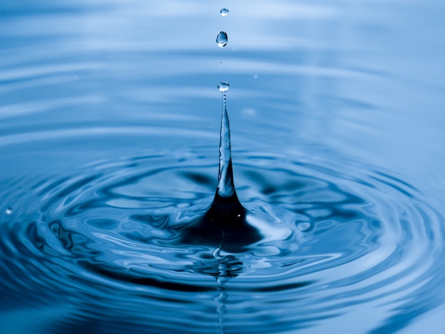 Bouchent la goutte d&#39;eau sur fond bleu