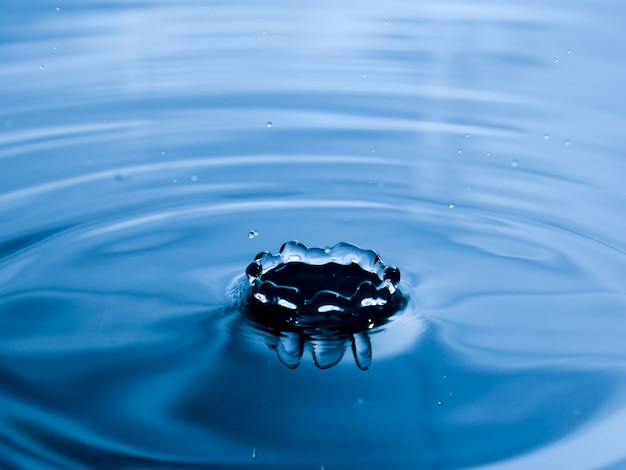 Bouchent la goutte d&#39;eau sur fond bleu