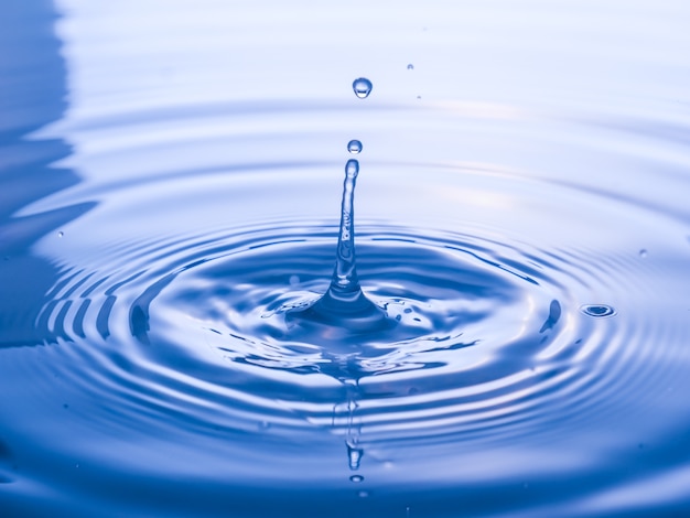 Photo bouchent la goutte d'eau sur fond bleu