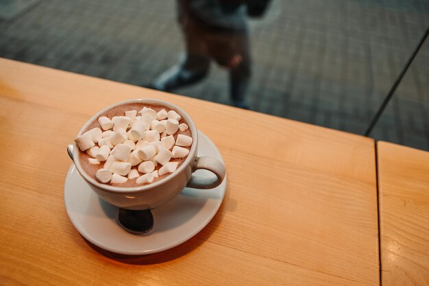 Bouchent la guimauve avec du café au lait cacao ou latte