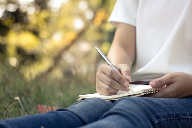 Bouchent les jeunes femmes écrivant sur ordinateur portable dans le parc, concept dans l&#39;éducation et la connaissance