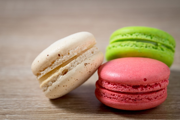 Bouchent le macaron ou le macaron de gâteau sur le fond en bois avec l'espace de copie, dessert sucré