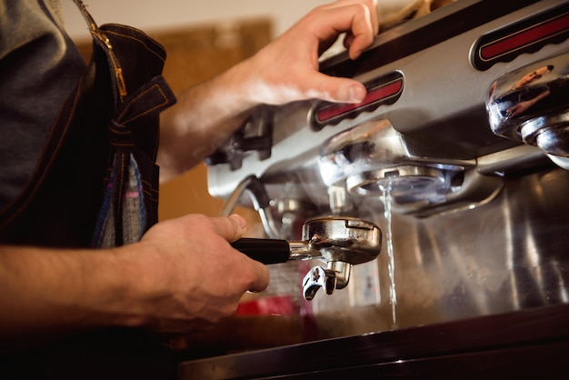 Bouchent la main de barista faisant une tasse de café