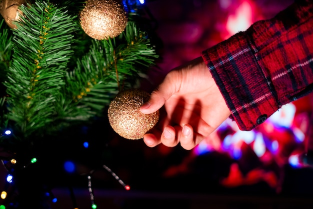 bouchent la main décorer le nouvel an des arbres de Noël avec des jouets à la maison.