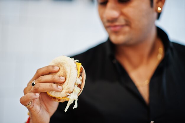 Bouchent la main de l'homme indien avec un délicieux burger.