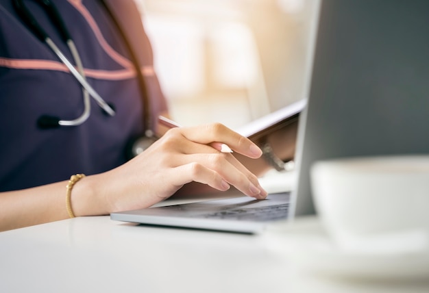 Bouchent la main de l&#39;infirmière courte en utilisant un ordinateur portable