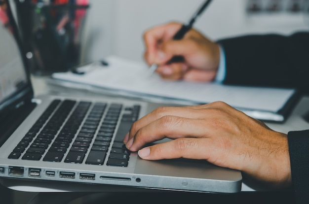 Bouchent la main en tapant sur le clavier d'un ordinateur portable