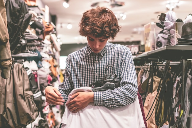 Bouchent la main tenant des tas de nouveaux vêtements à acheter dans le magasin, un concept de vente shopping