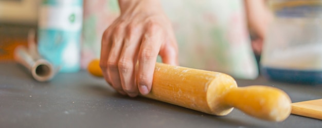 Bouchent les mains che tenant le rouleau à pâtisserie et la préparation des aliments