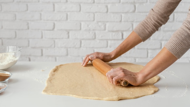 Bouchent les mains étalant la pâte