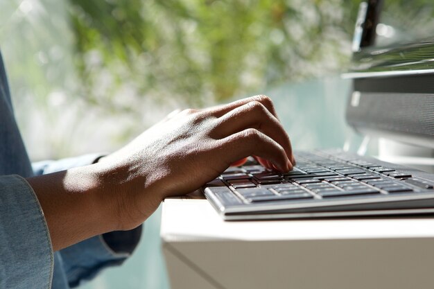 Bouchent les mains féminines sur le clavier d&#39;ordinateur portable