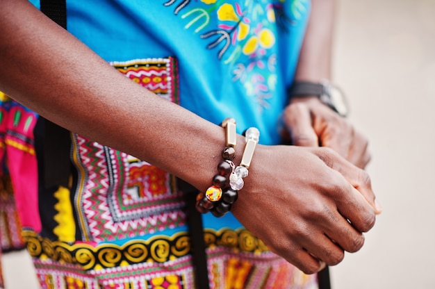 Bouchent les mains de l'homme africain en chemise traditionnelle africaine avec bracelets.