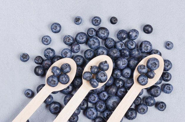 Bouchent les myrtilles des tourbières sur une cuillère en bois. Concept de nutrition saine