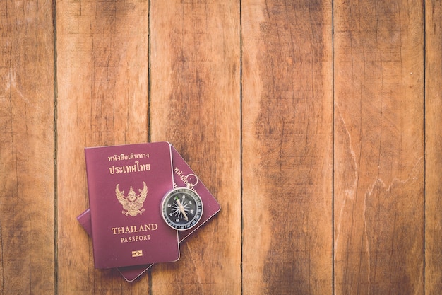 Bouchent le passeport de la Thaïlande et la boussole sur bois