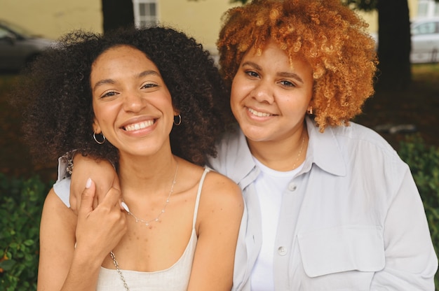 Bouchent portrait belle belle heureuse couple afro-américain de lesbiennes étreignant autour de la rue de la ville