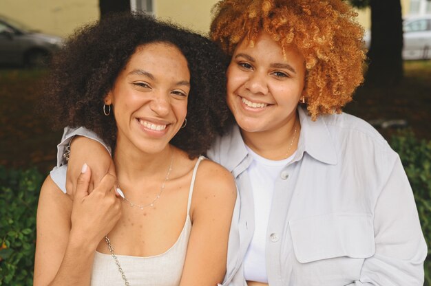 Bouchent portrait belle belle heureuse couple afro-américain de lesbiennes étreignant autour de la rue de la ville