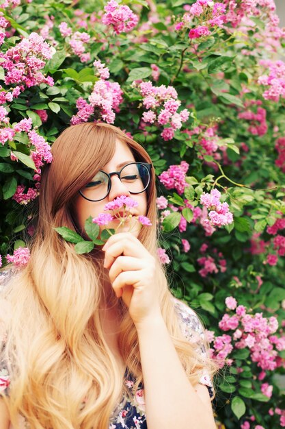 Bouchent le portrait d'une belle fille dans le jardin de roses