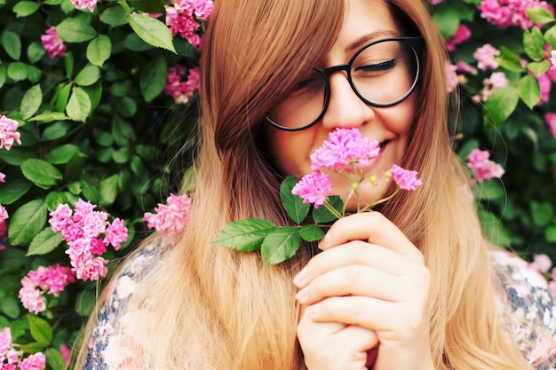 Bouchent le portrait d'une belle fille dans le jardin de roses