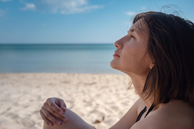 Bouchent le portrait de la belle jeune femme sur la plage