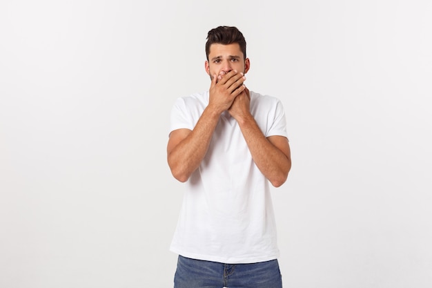 Bouchent le portrait du séduisant jeune homme fermant la bouche avec les doigts. Geste inquiet, je ne peux rien dire.