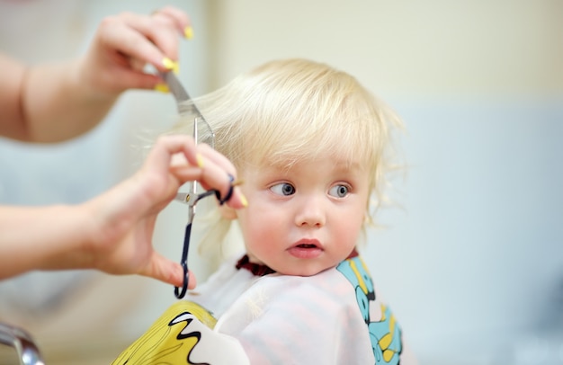 Bouchent le portrait d&#39;un enfant en bas âge faisant sa première coupe de cheveux