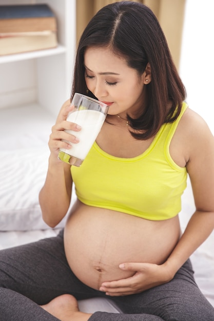 Bouchent le portrait d'une femme enceinte en bonne santé, buvant un verre de lait