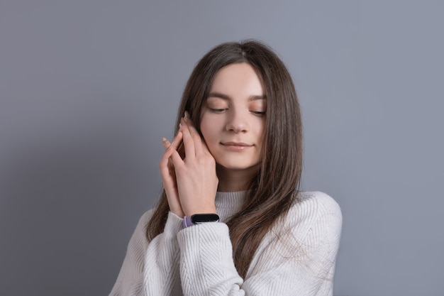 Bouchent le portrait de femme jeune belle fille souriante heureuse touchant son visage, joues plaisir.