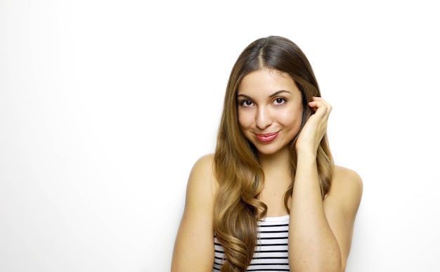 Bouchent le portrait d'une femme positive naturelle assez joyeuse avec la main près de l'oreille