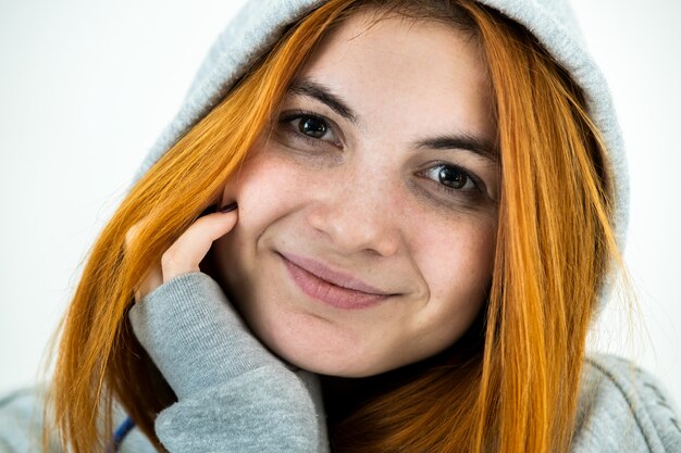 Bouchent le portrait de femme souriante jeune rousse souriante portant un pull à capuche chaud.