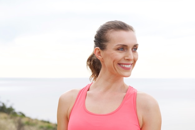 Bouchent portrait de femme sport souriant à l&#39;extérieur