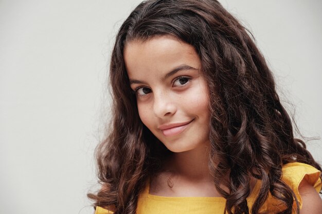 Bouchent le portrait d'une fille preteen multiculturelle mélangée confiante et magnifique avec de beaux cheveux bouclés.