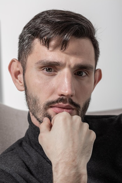 Bouchent le portrait d'un homme barbu mignon regardant sérieusement et directement l'appareil photo