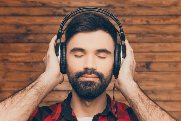 Bouchent le portrait d'un homme détendu dans un casque d'écoute de la musique avec les yeux fermés