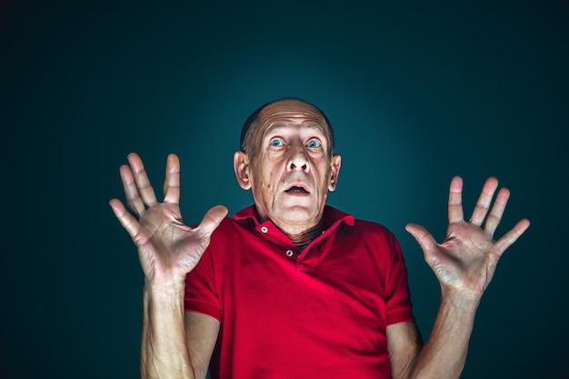 Photo bouchent le portrait d'un homme effrayé et choqué fou isolé sur fond sombre