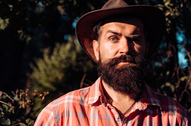 Photo bouchent le portrait d'un homme sérieux au chapeau de cowboy