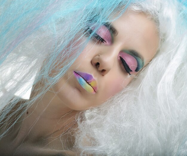 Bouchent portrait jeune femme avec maquillage lumineux et cheveux créatifs