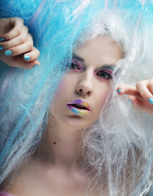 Bouchent portrait jeune femme avec maquillage lumineux et cheveux créatifs