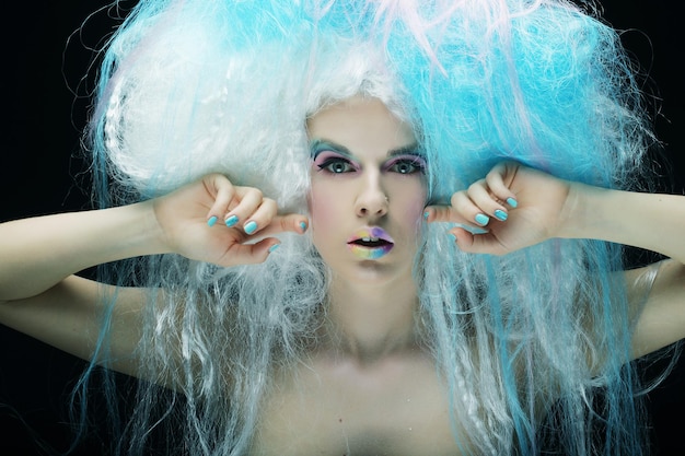 Bouchent portrait jeune femme avec maquillage lumineux et cheveux créatifs