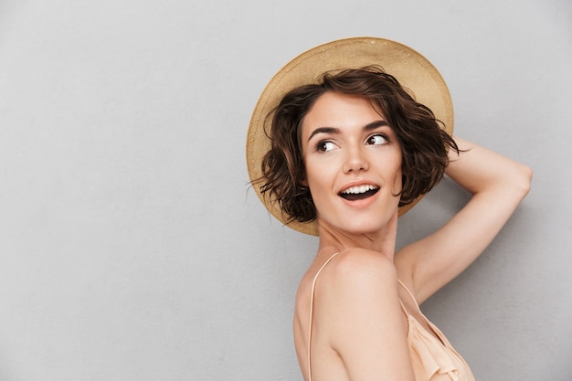 Bouchent le portrait d'une jeune femme souriante au chapeau