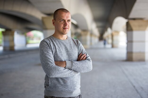 Bouchent portrait de jeune homme posant sous un pont en béton